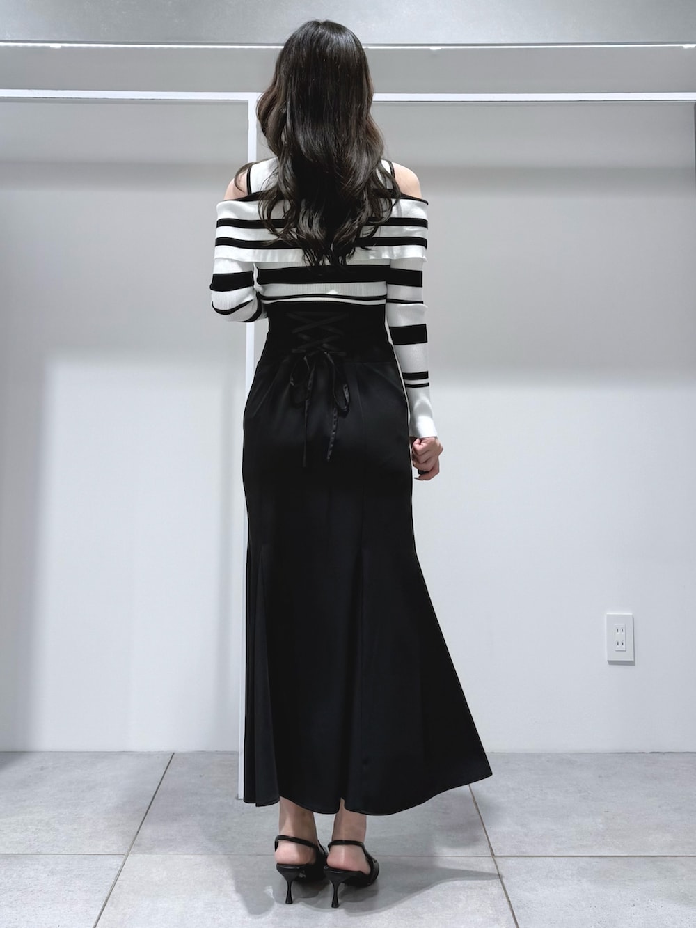 その他のニット/セーター、ブラック系のスカート、ブラック系のパンプスを着用したレディースの春コーディネートの4枚目の写真