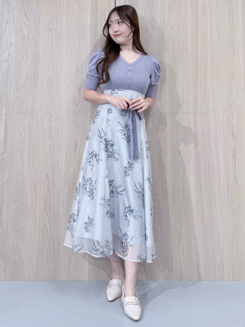 パープル系のワンピース、ホワイト系のパンプスを着用したレディースの冬コーディネートの2枚目の写真