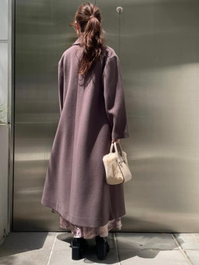 ホワイト系のハンドバッグ、ブラウン系のチェスターコート、レッド系のニット/セーターを着用したレディースの秋コーディネートの5枚目の写真