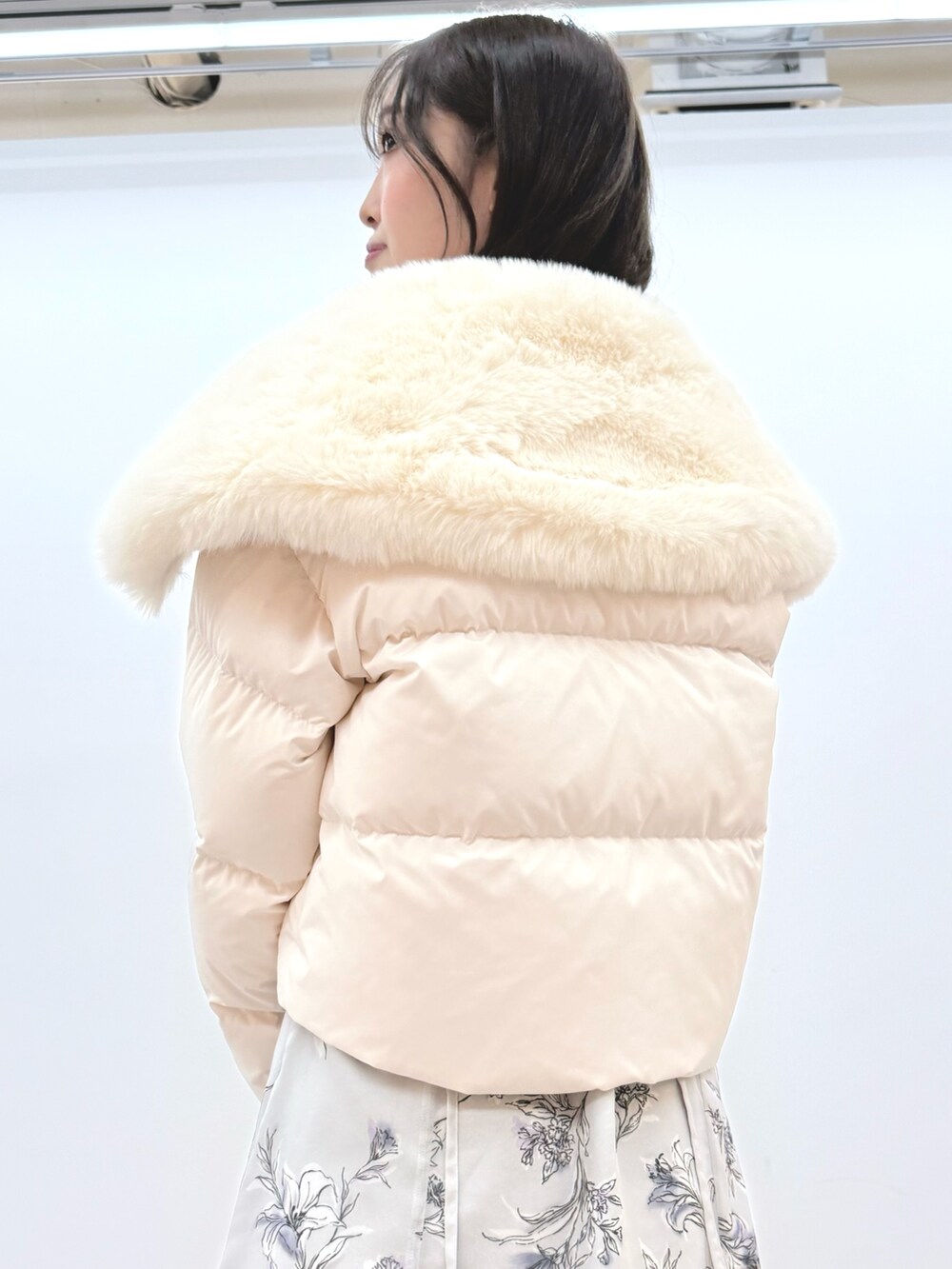 ホワイト系のダウンジャケット/コート、シルバー系のハンドバッグ、ブラック系のブーツを着用したレディースの秋コーディネートの6枚目の写真