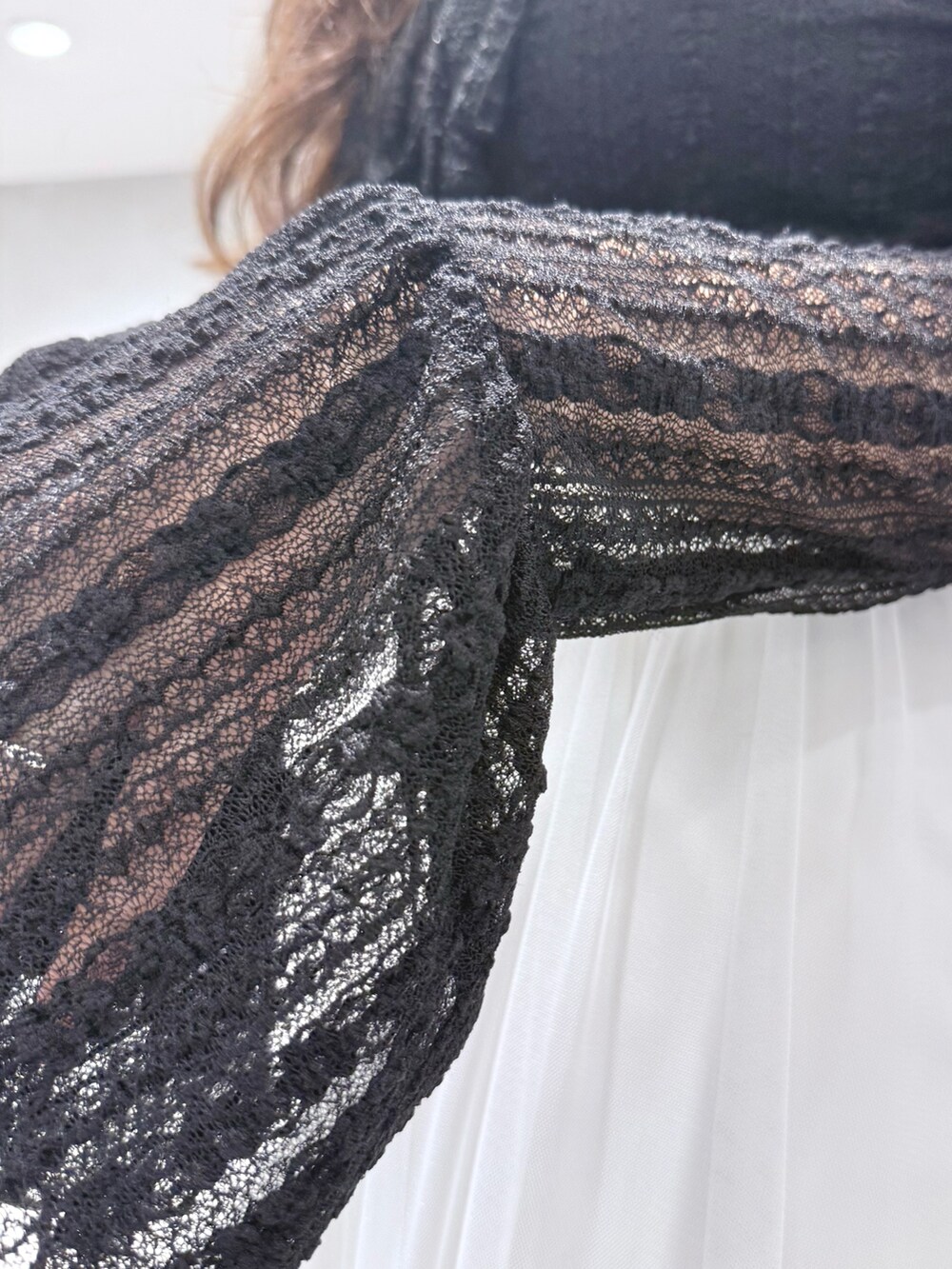 ブラック系のブーツ、ホワイト系のスカート、ブラック系のTシャツ/カットソーを着用したレディースの秋コーディネートの8枚目の写真