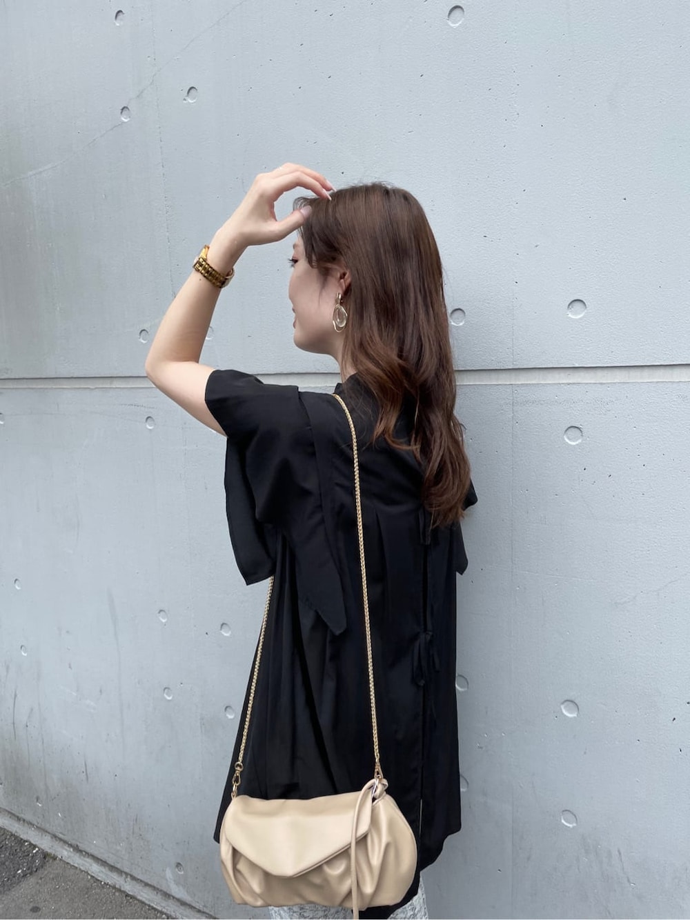 ブラック系のサンダル、ブラック系のシャツ/ブラウス、ホワイト系のクラッチバッグを着用したレディースの夏コーディネートの4枚目の写真