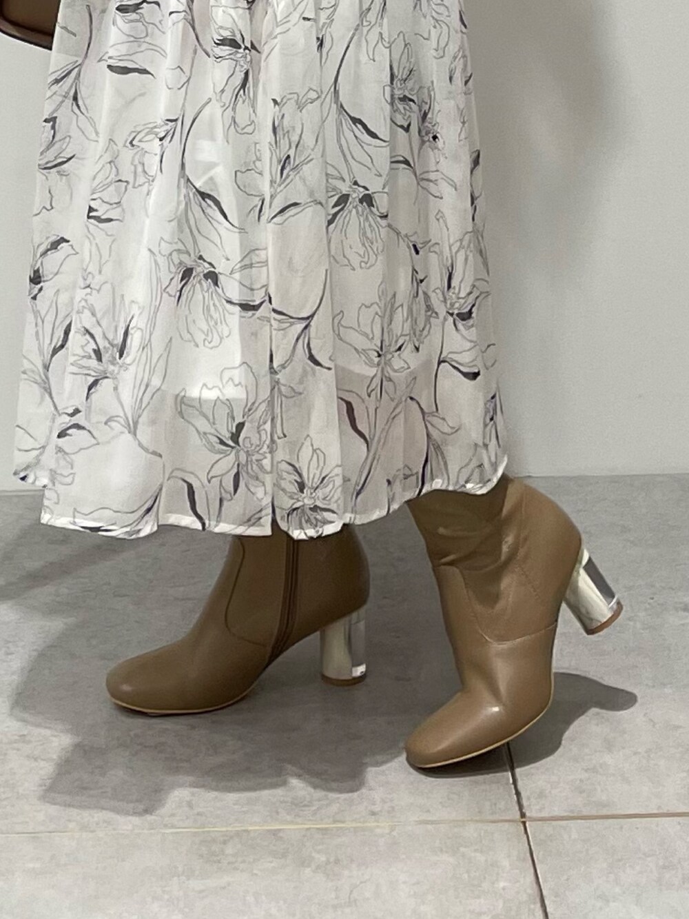 ホワイト系のワンピース、ブラウン系のハンドバッグ、ブラウン系のブーツを着用したレディースの秋コーディネートの7枚目の写真