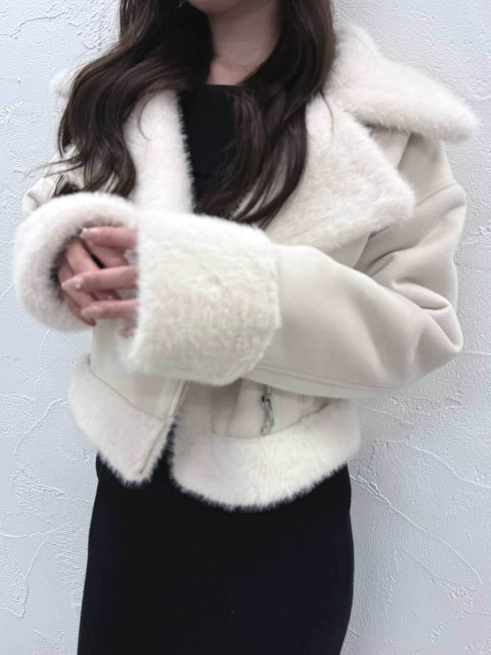 ブラック系のワンピース、ブラック系のブーツ、ホワイト系のムートンコートを着用したレディースの秋コーディネートの6枚目の写真