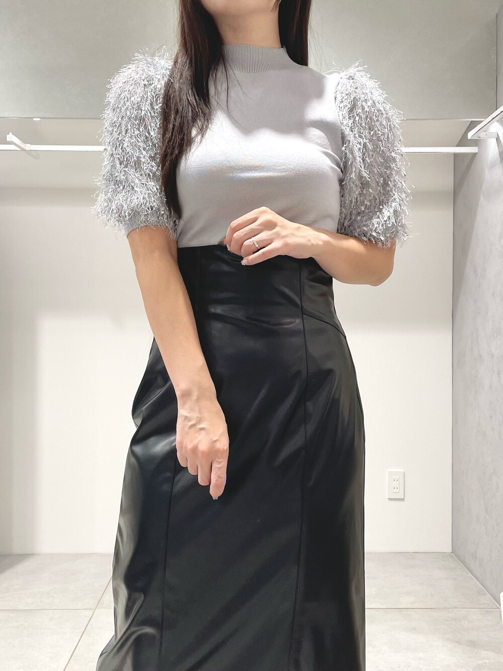 グレー系のニット/セーター、ブラック系のスカート、ブラック系のショルダーバッグを着用したレディースの秋コーディネートの5枚目の写真