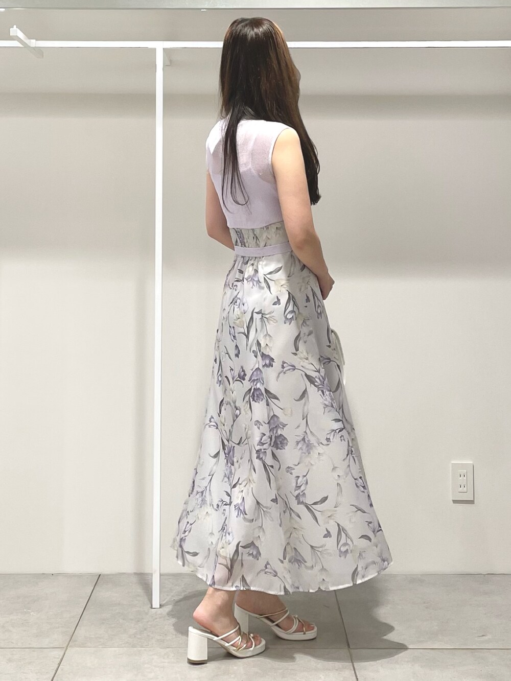 ホワイト系のハンドバッグ、ホワイト系のサンダル、パープル系のワンピースを着用したレディースの夏コーディネートの3枚目の写真