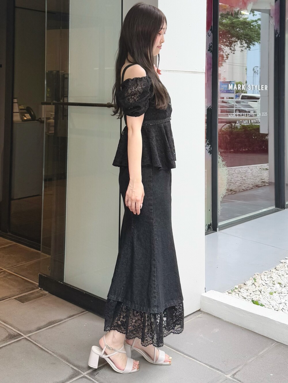 ブラック系のシャツ/ブラウス、ブラック系のスカート、ベージュ系のサンダルを着用したレディースの夏コーディネートの4枚目の写真