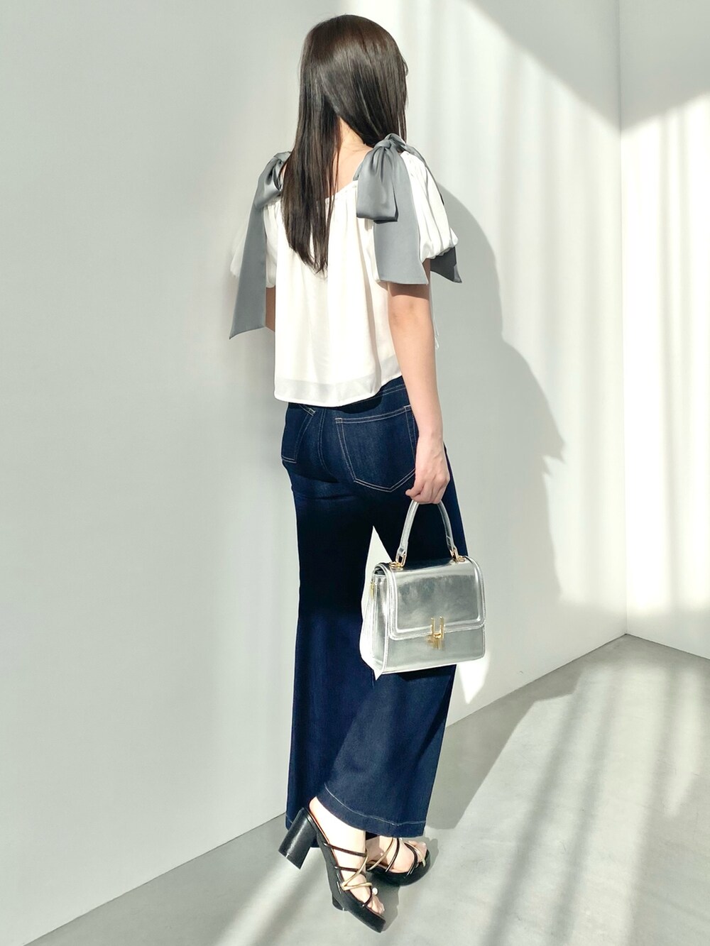 ホワイト系のシャツ/ブラウス、ブルー系のデニムパンツ、ブラック系のサンダルを着用したレディースの春コーディネートの3枚目の写真