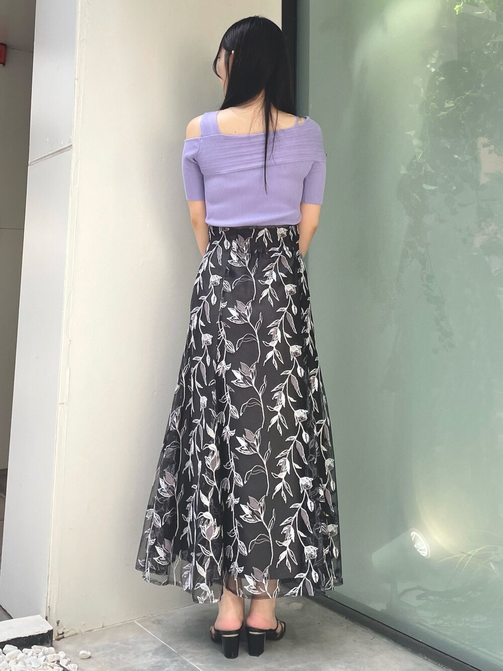 グレー系のスカート、パープル系のニット/セーター、ブラック系のサンダルを着用したレディースの夏コーディネートの3枚目の写真