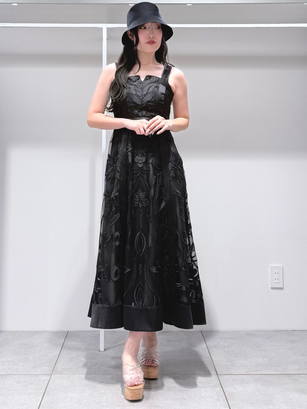 ブラック系のワンピース、その他のサンダル、ブラック系のハットを着用したレディースの夏コーディネートの2枚目の写真