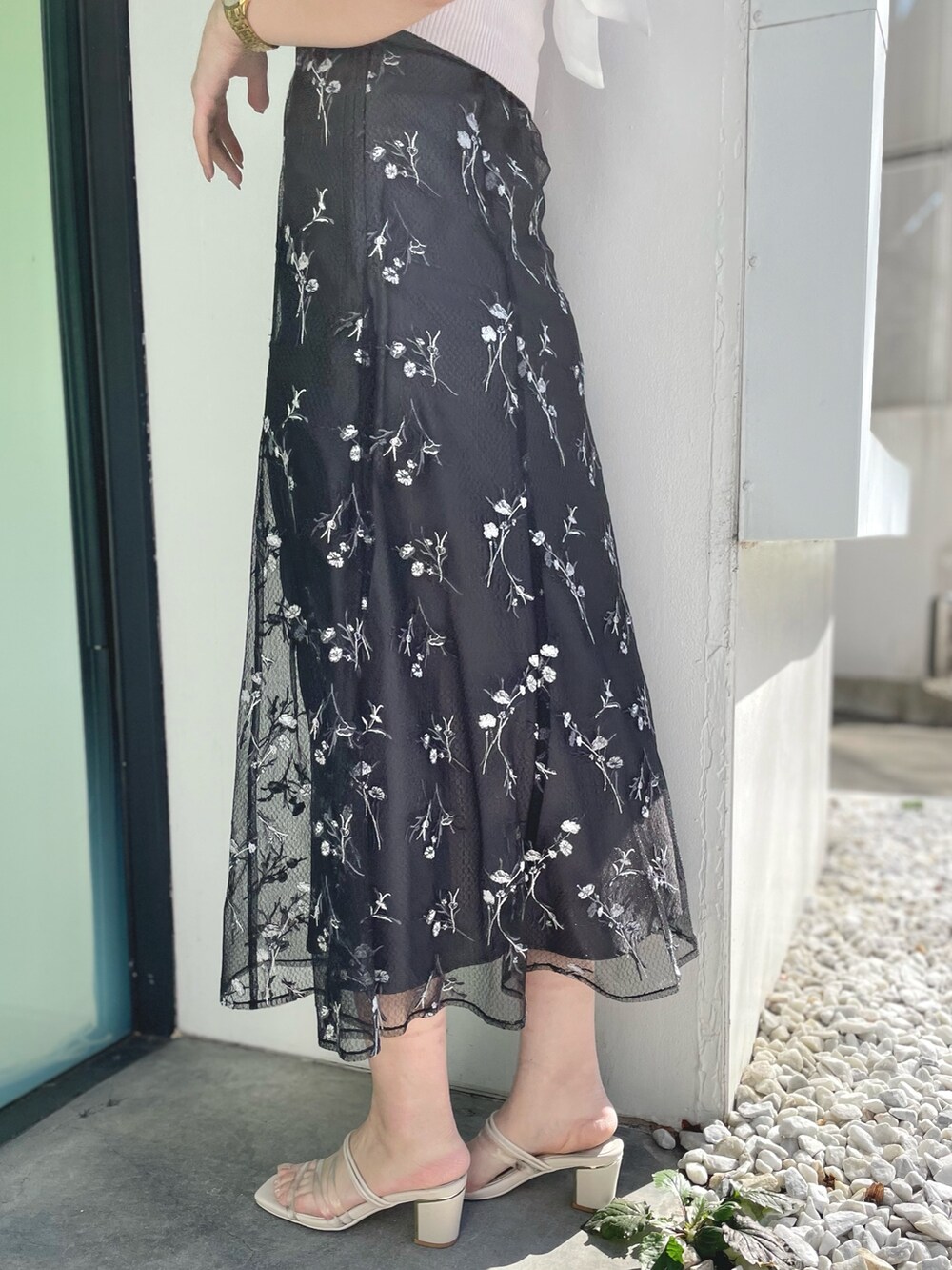 ピンク系のニット/セーター、グレー系のスカート、ホワイト系のサンダルを着用したレディースの春コーディネートの6枚目の写真