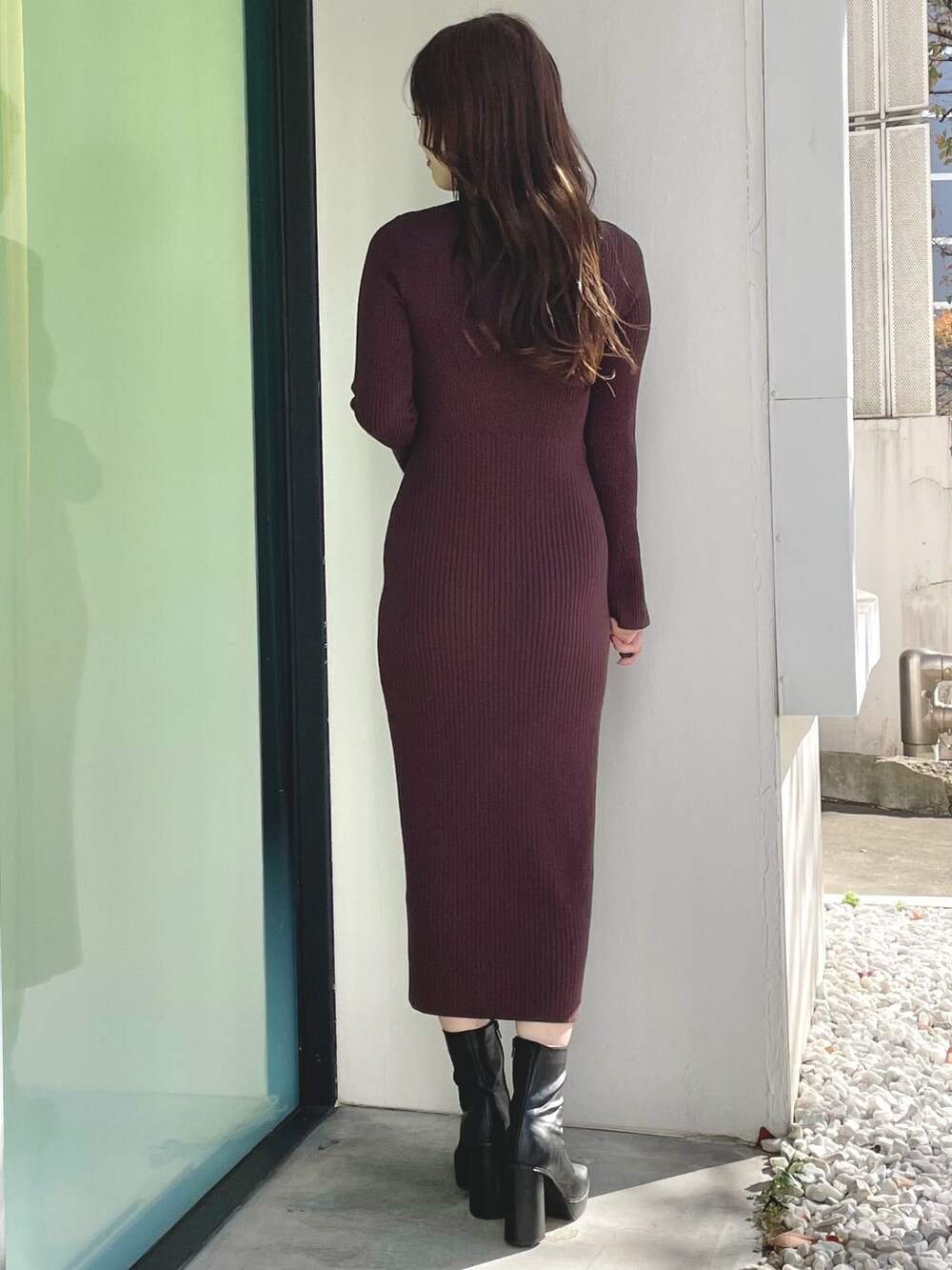 ブラック系のダウンジャケット/コート、ブラウン系のワンピース、ブラック系のブーツを着用したレディースの冬コーディネートの7枚目の写真