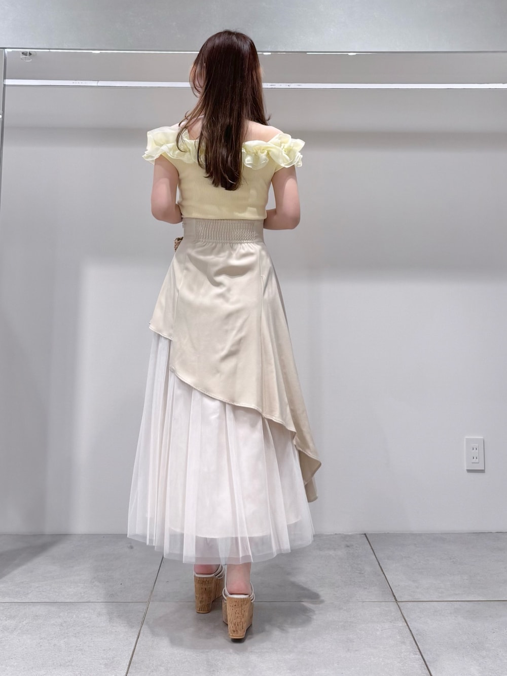 ベージュ系のスカート、その他のサンダル、ベージュ系のハンドバッグを着用したレディースの春コーディネートの3枚目の写真