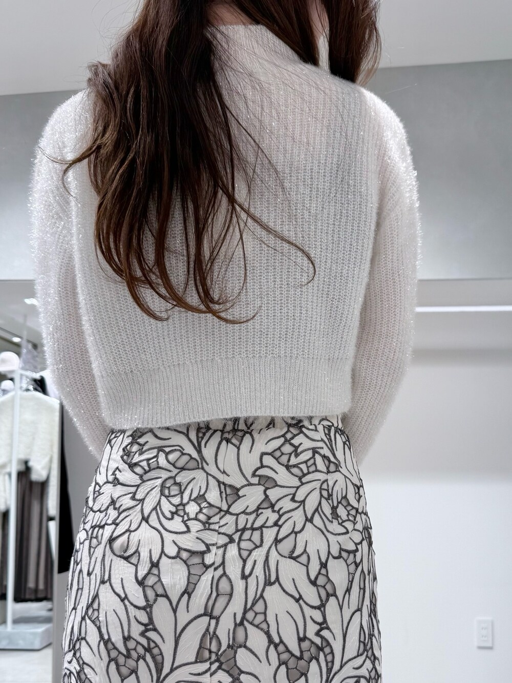 ホワイト系のニット/セーター、ホワイト系のスカート、ホワイト系のブーツを着用したレディースの冬コーディネートの7枚目の写真