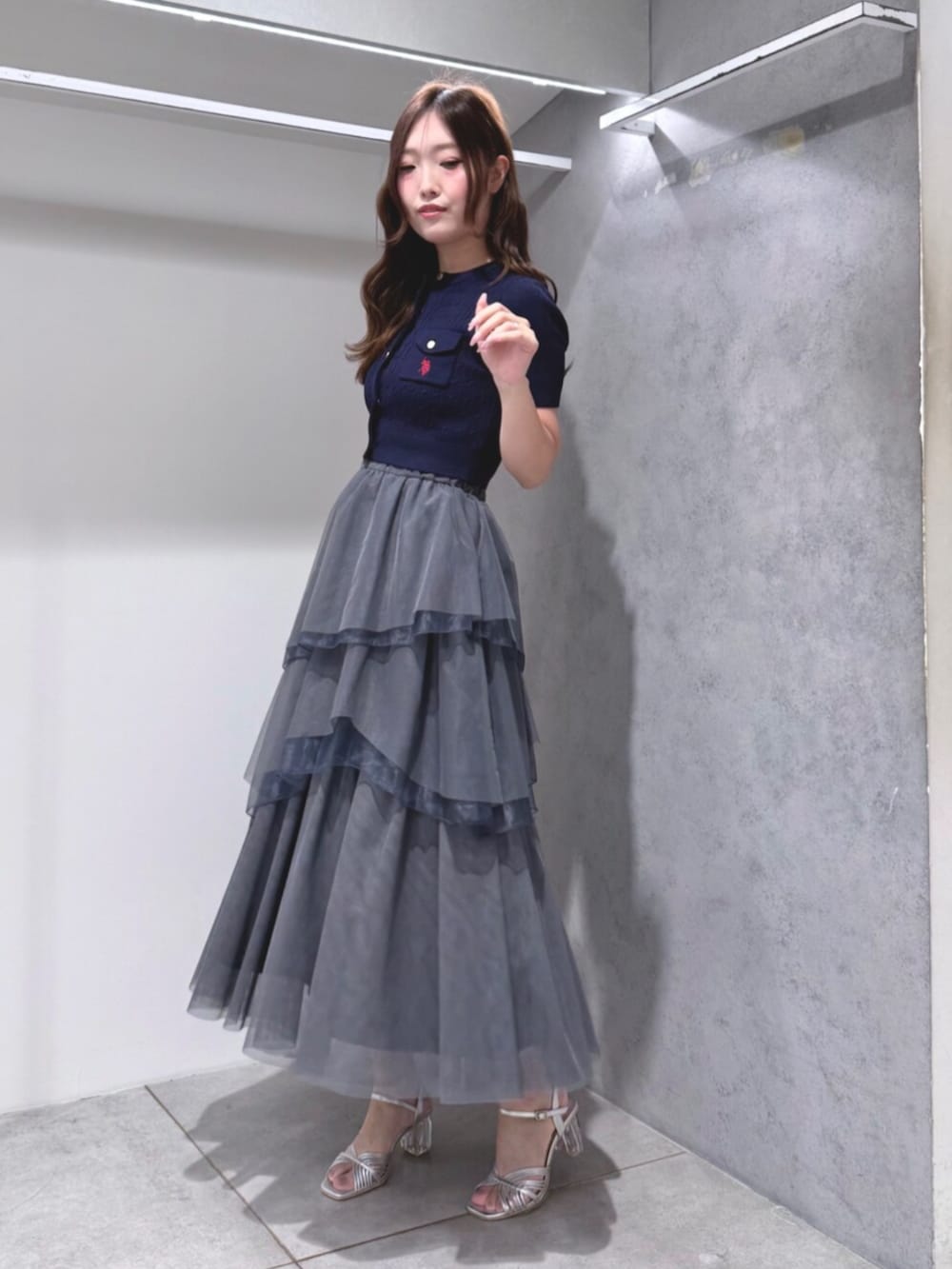 シルバー系のサンダル、ブルー系のカーディガン/ボレロ、グレー系のスカートを着用したレディースの夏コーディネートの2枚目の写真