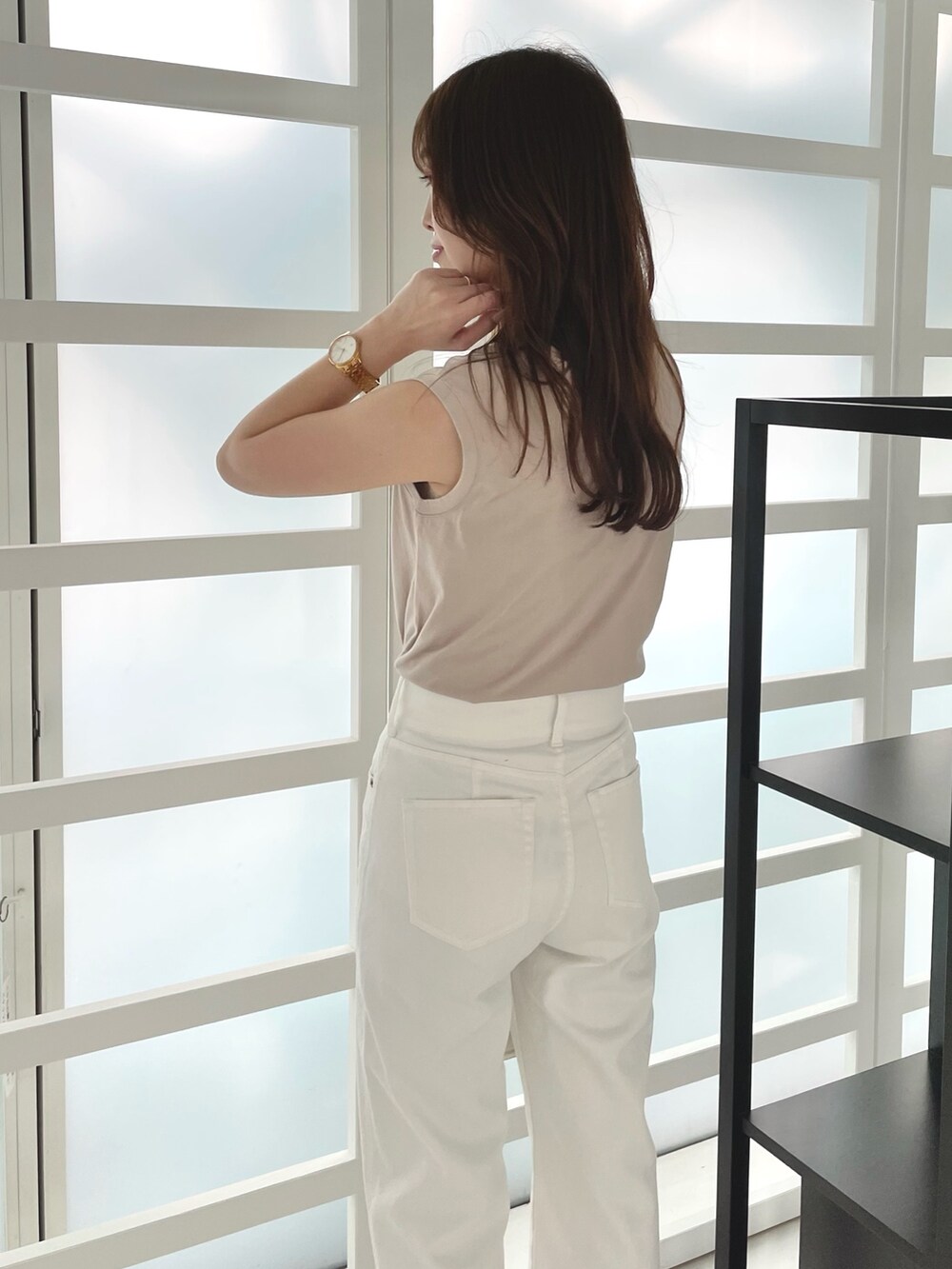 ホワイト系のデニムパンツ、その他のサンダル、ホワイト系のハンドバッグを着用したレディースの春コーディネートの5枚目の写真