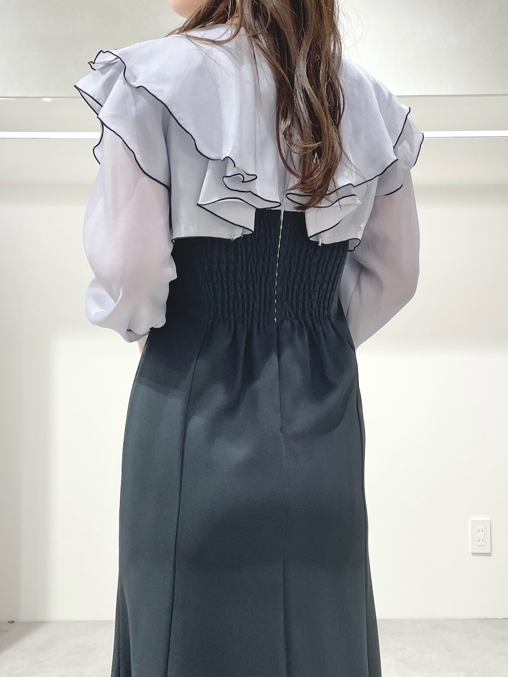 グレー系のワンピース、ホワイト系のブーツ、ホワイト系のハンドバッグを着用したレディースの冬コーディネートの6枚目の写真