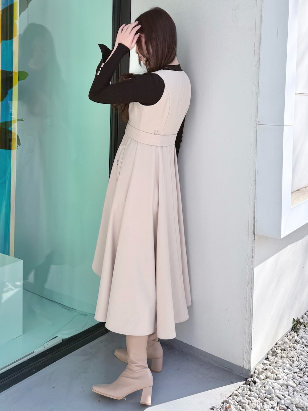 ベージュ系のワンピース、ベージュ系のブーツ、ベージュ系のトレンチコートを着用したレディースの冬コーディネートの7枚目の写真