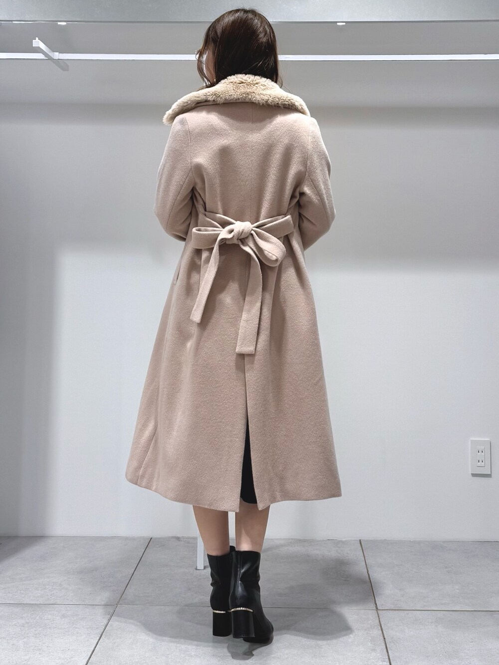 ベージュ系のその他アウター、ホワイト系のハンドバッグ、ブラック系のワンピースを着用したレディースの冬コーディネートの4枚目の写真