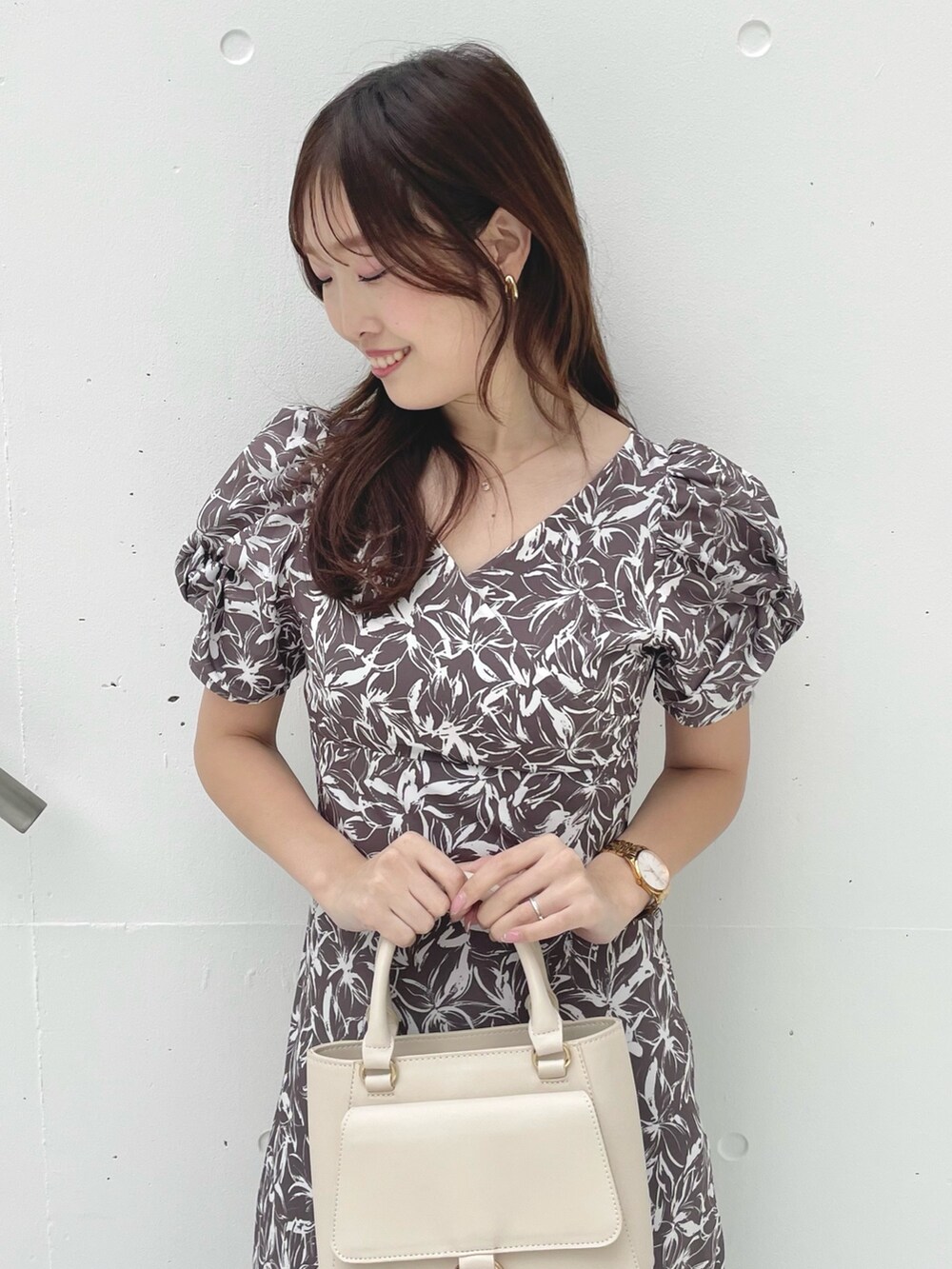 グレー系のワンピース、ブラック系のサンダル、ホワイト系のハンドバッグを着用したレディースの春コーディネートの5枚目の写真