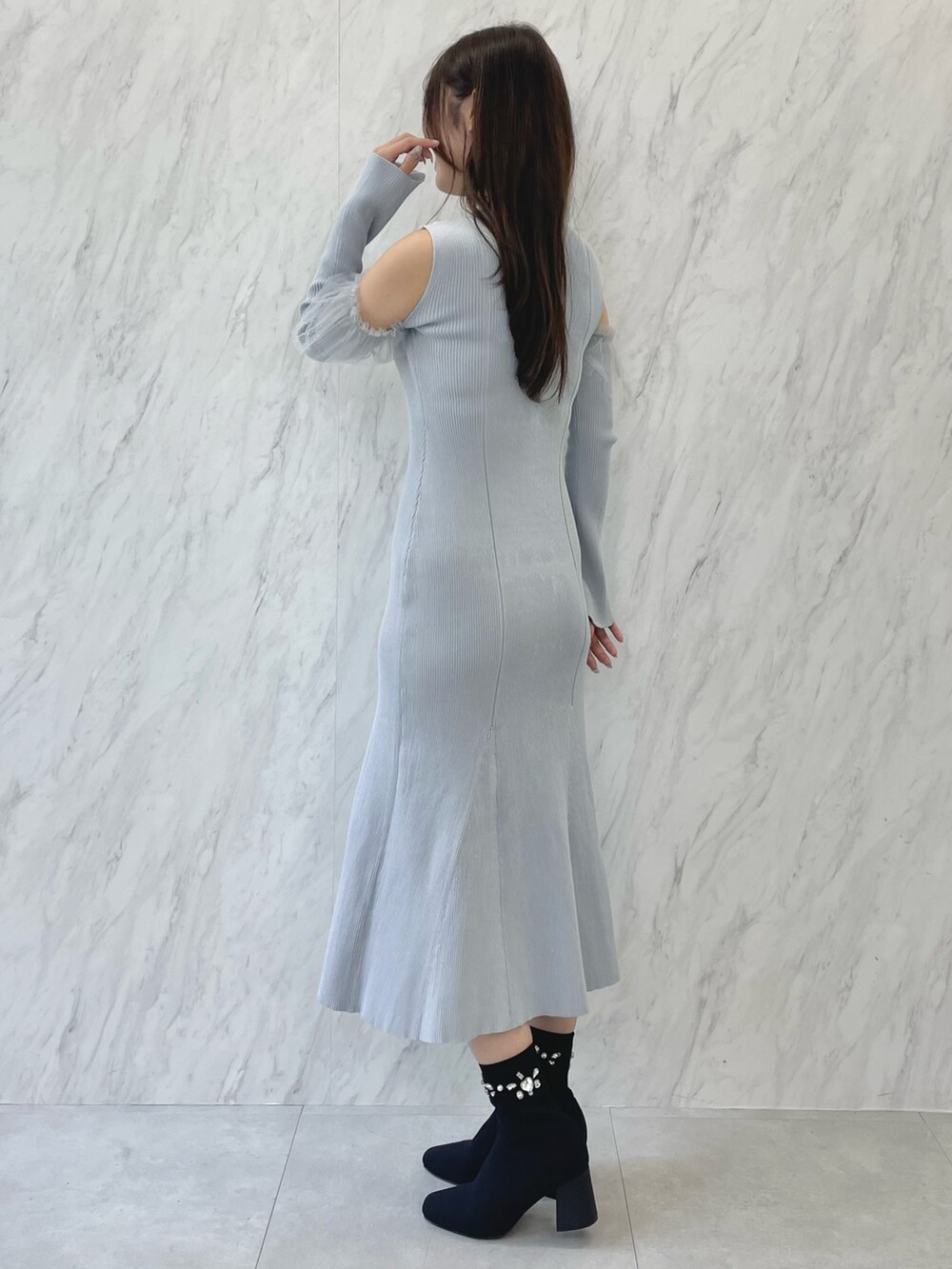 ブルー系のワンピース、ブラック系のブーツ、ベージュ系のムートンコートを着用したレディースの秋コーディネートの7枚目の写真