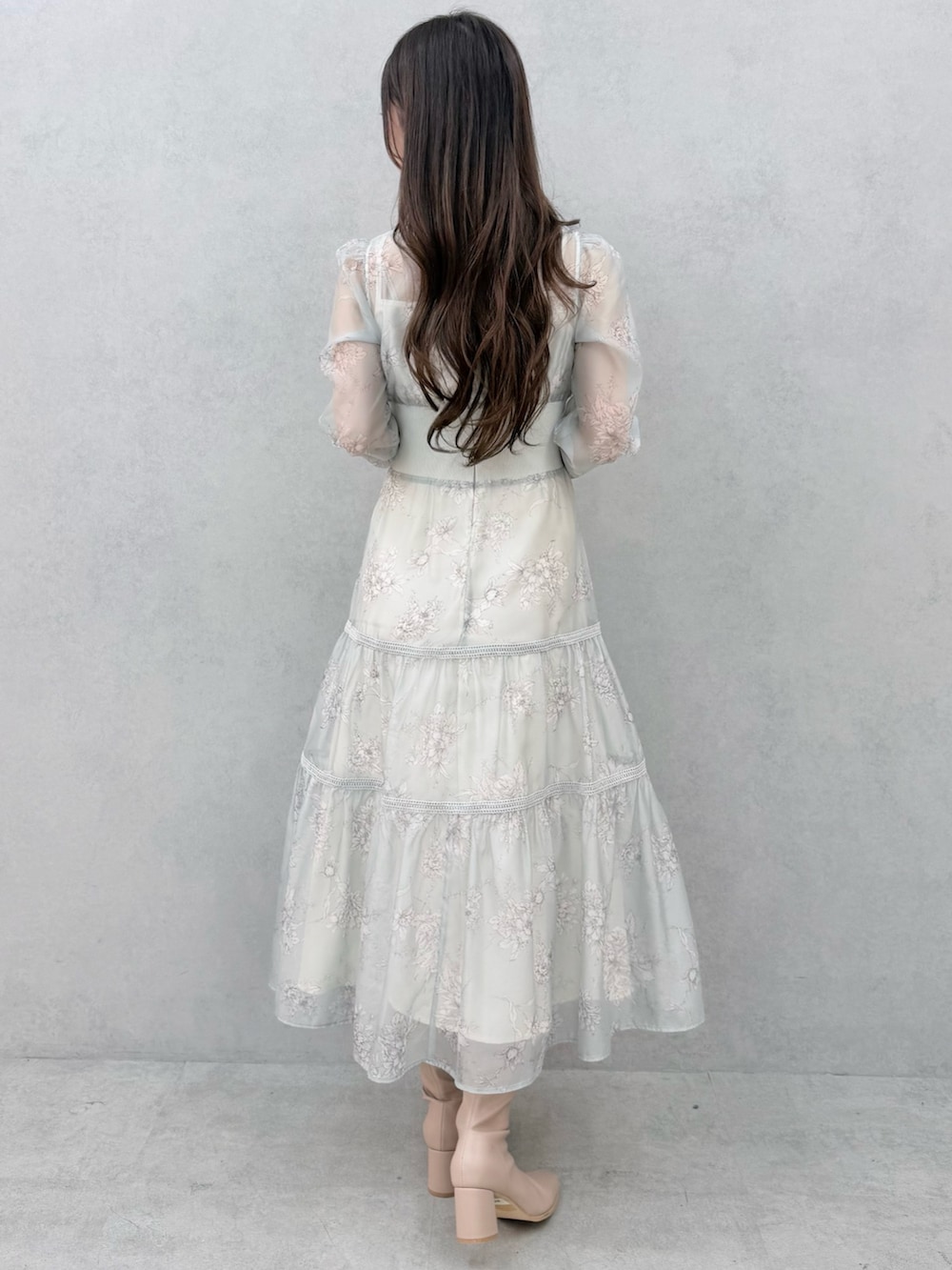 グリーン系のワンピース、ベージュ系のブーツを着用したレディースの冬コーディネートの3枚目の写真