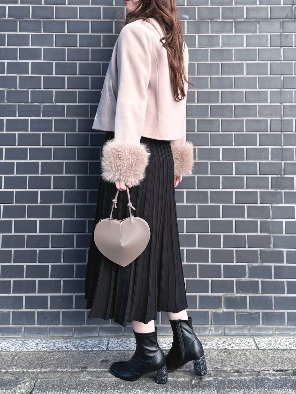 ブラック系のブーツ、ブラック系のワンピース、ベージュ系のショルダーバッグを着用したレディースの冬コーディネートの3枚目の写真