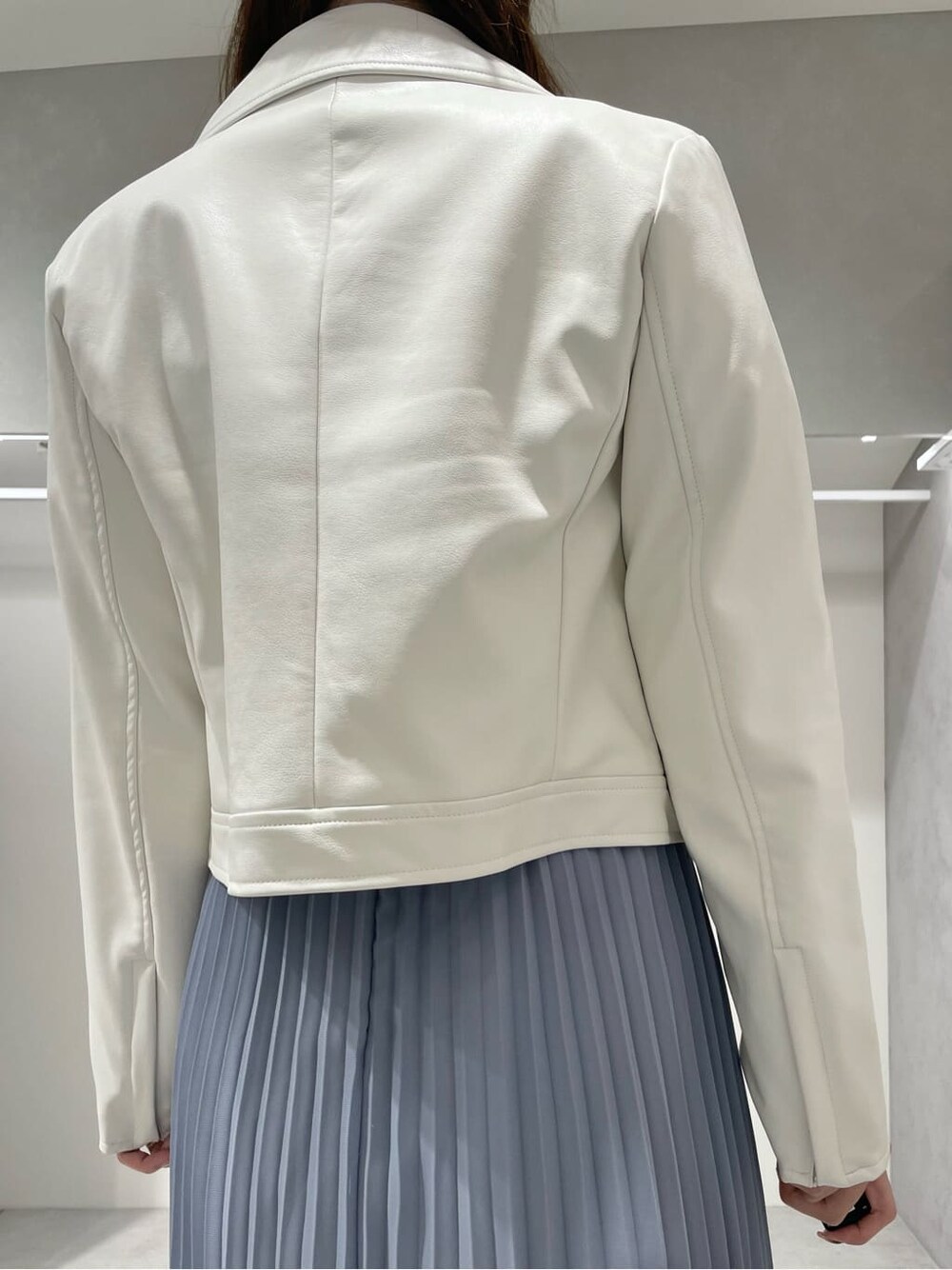 ホワイト系のブーツ、ホワイト系のライダースジャケット、ブルー系のワンピースを着用したレディースの秋コーディネートの7枚目の写真