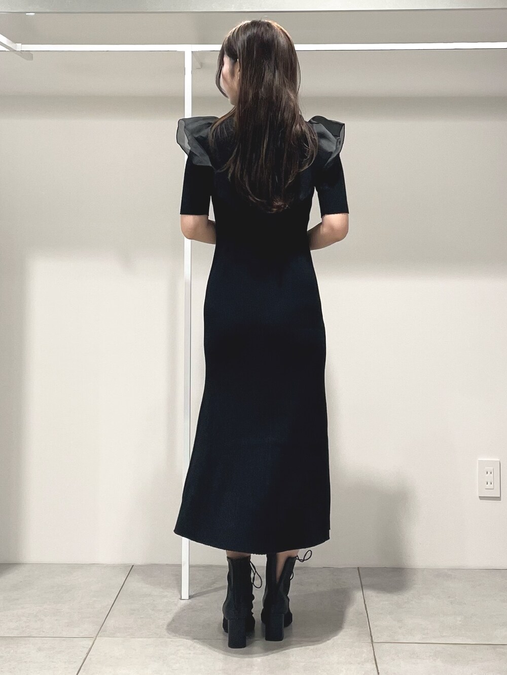 ブラック系のワンピース、ブラック系のハンドバッグ、ブラック系のブーツを着用したレディースの秋コーディネートの4枚目の写真