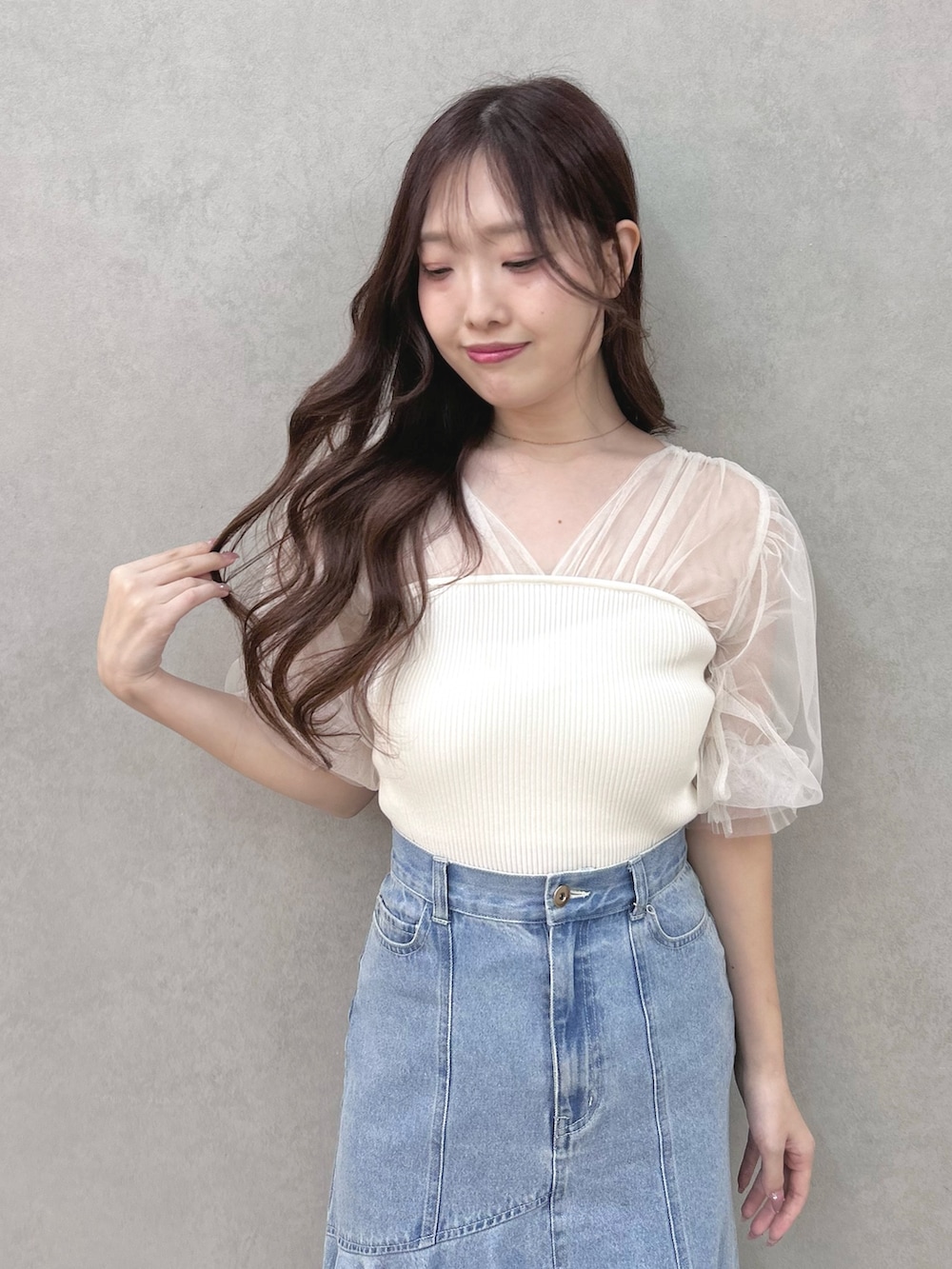 ホワイト系のニット/セーター、ブルー系のスカート、シルバー系のサンダルを着用したレディースの春コーディネートの4枚目の写真