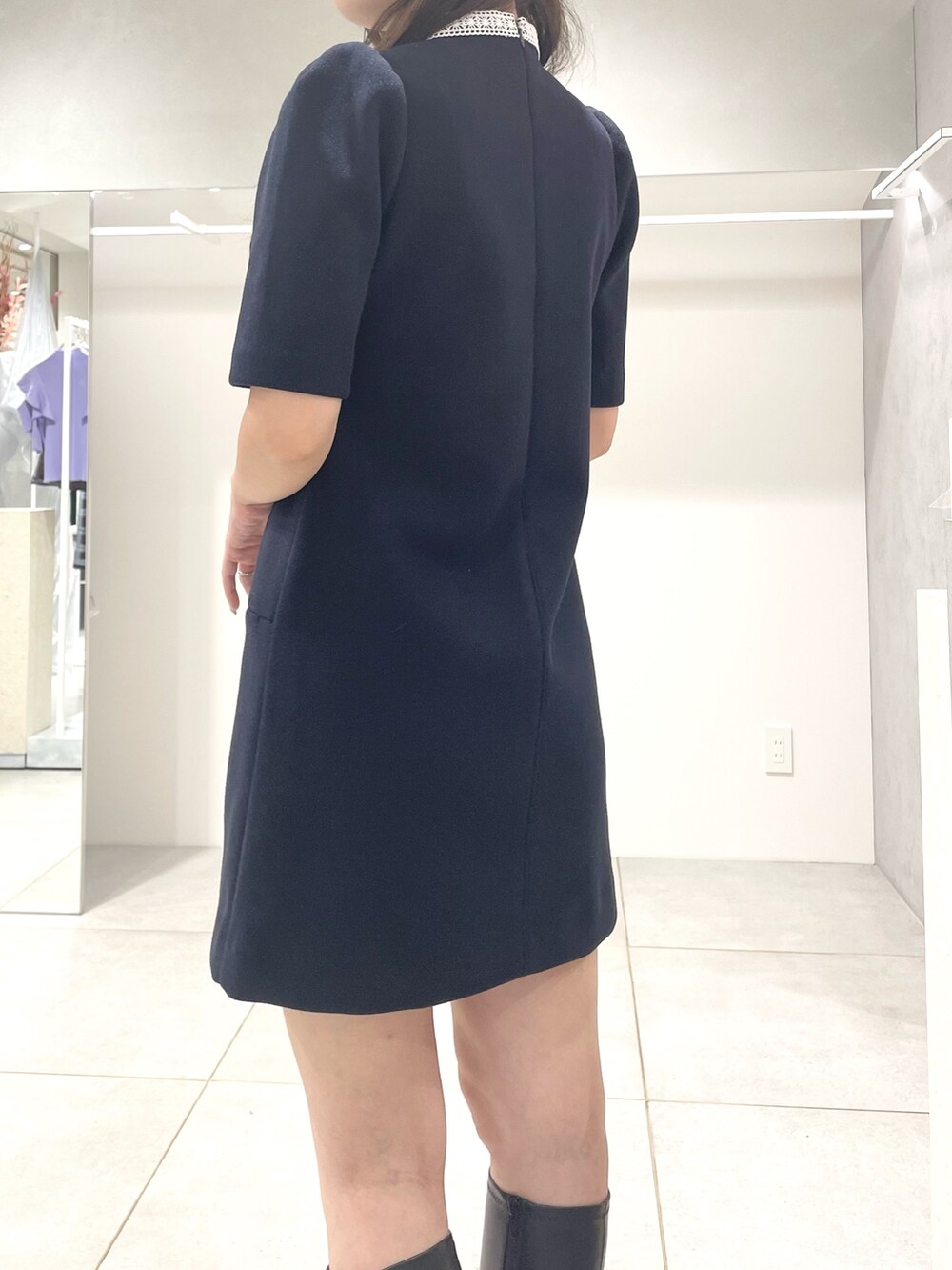 ブルー系のワンピース、ブラック系のブーツ、グレー系のハンドバッグを着用したレディースの秋コーディネートの6枚目の写真