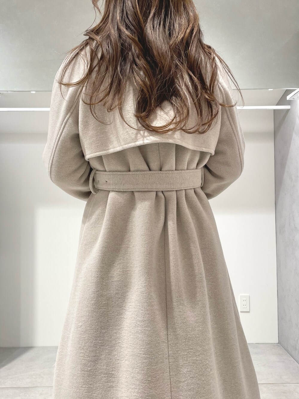 ブラック系のスカート、ブラック系のブーツ、ホワイト系のニット/セーターを着用したレディースの秋コーディネートの5枚目の写真