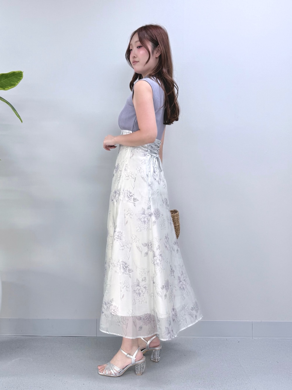 パープル系のワンピース、ベージュ系のハンドバッグ、シルバー系のサンダルを着用したレディースの夏コーディネートの2枚目の写真