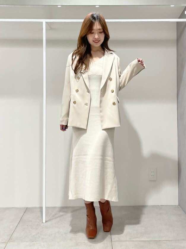 ブラウン系のブーツ、ベージュ系のテーラードジャケット、ホワイト系のワンピースを着用したレディースの秋コーディネートの3枚目の写真