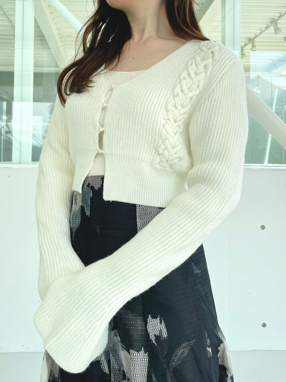 ブラック系のスカート、ブラック系のブーツ、ホワイト系のカーディガン/ボレロを着用したレディースの秋コーディネートの6枚目の写真