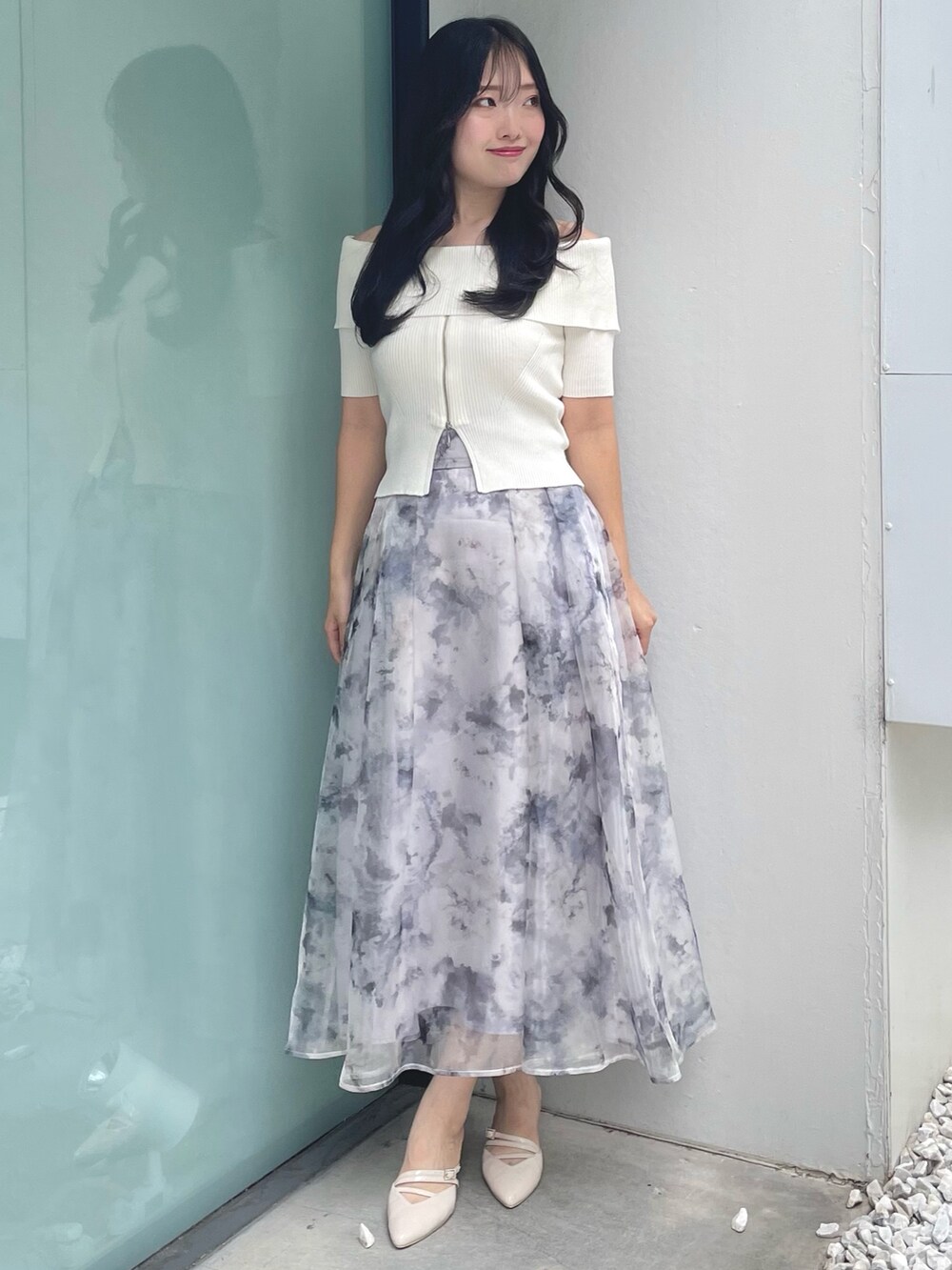 ホワイト系のニット/セーター、グレー系のスカート、ベージュ系のパンプスを着用したレディースの夏コーディネートの2枚目の写真
