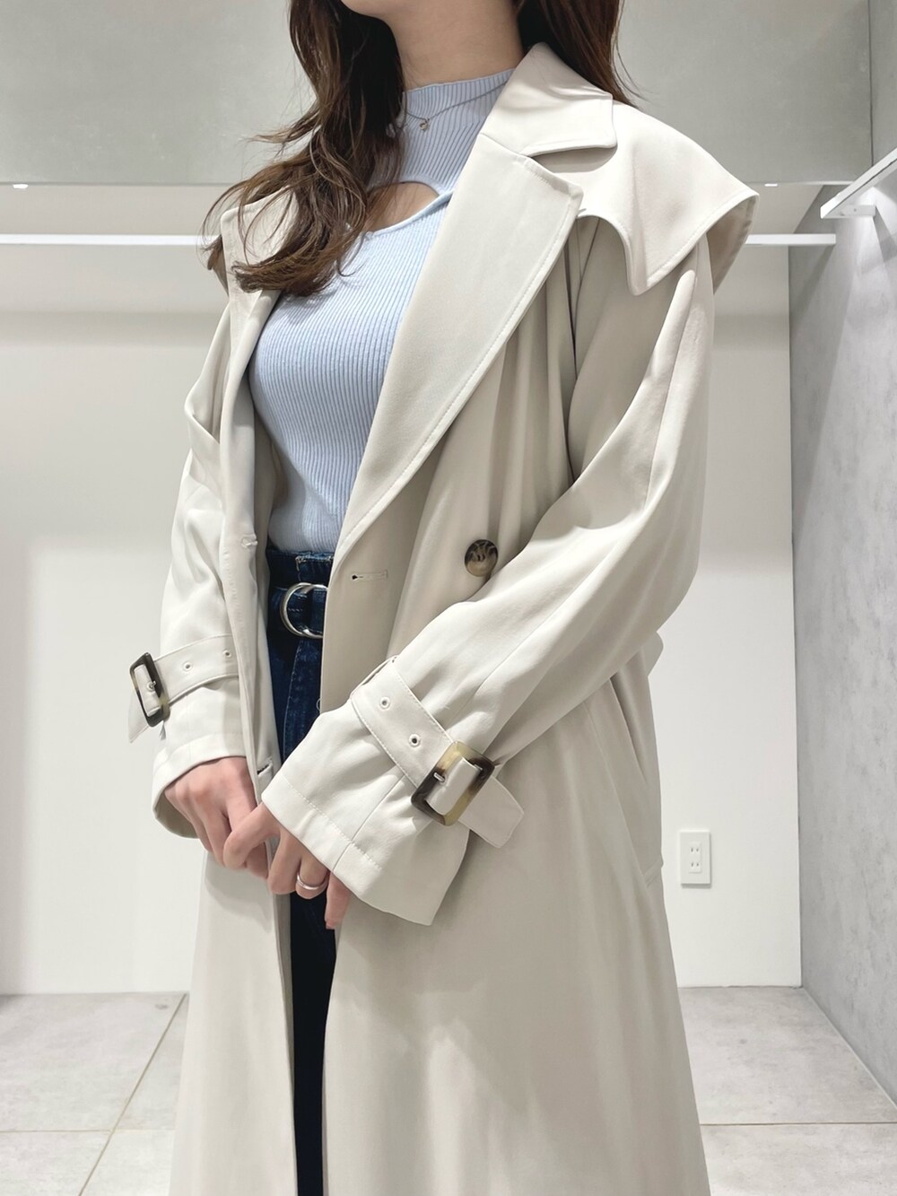 ホワイト系のハンドバッグ、ブラック系のブーツ、ブルー系のニット/セーターを着用したレディースの冬コーディネートの5枚目の写真