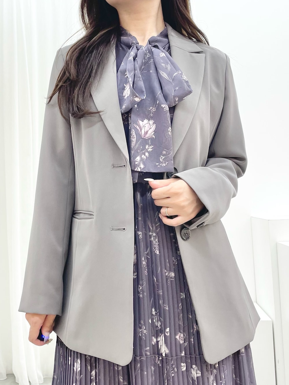 グレー系のワンピース、ブラック系のブーツ、グレー系のテーラードジャケットを着用したレディースの秋コーディネートの4枚目の写真