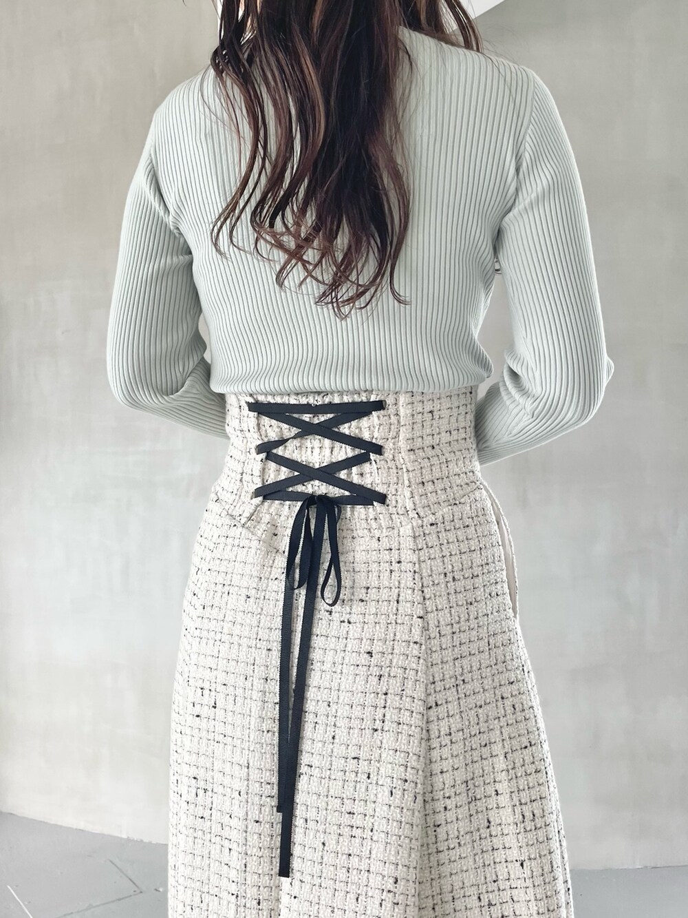 ホワイト系のスカート、ベージュ系のブーツ、グリーン系のニット/セーターを着用したレディースの秋コーディネートの6枚目の写真