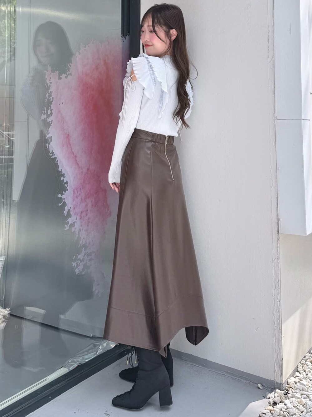 ブラウン系のスカート、ブルー系のニット/セーター、ブラック系のブーツを着用したレディースの秋コーディネートの3枚目の写真