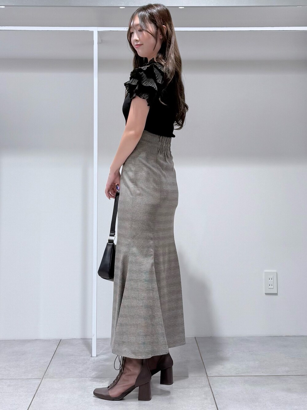 その他のスカート、ブラック系のニット/セーター、ブラック系のハンドバッグを着用したレディースの夏コーディネートの3枚目の写真