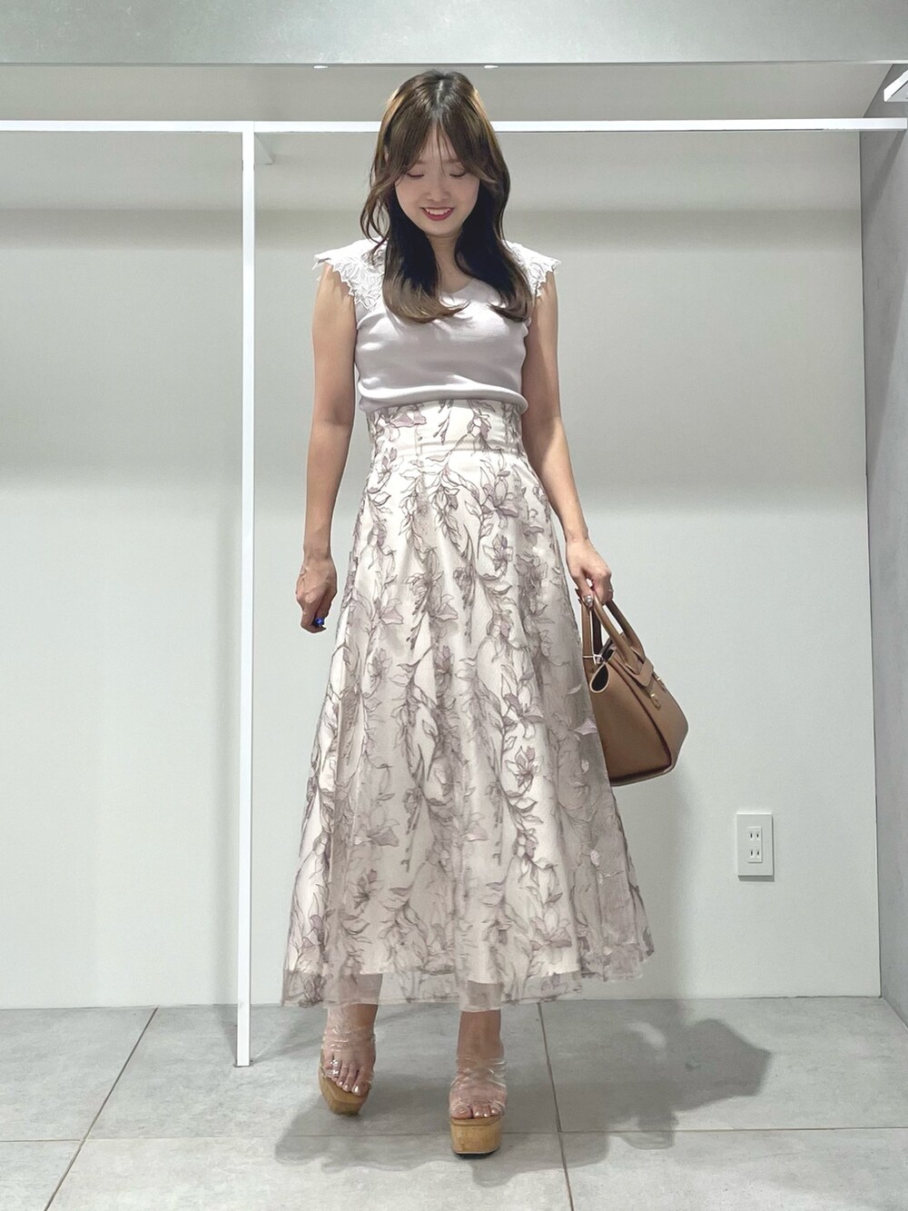 ブラウン系のトートバッグ、ピンク系のスカート、その他のサンダルを着用したレディースの夏コーディネートの2枚目の写真