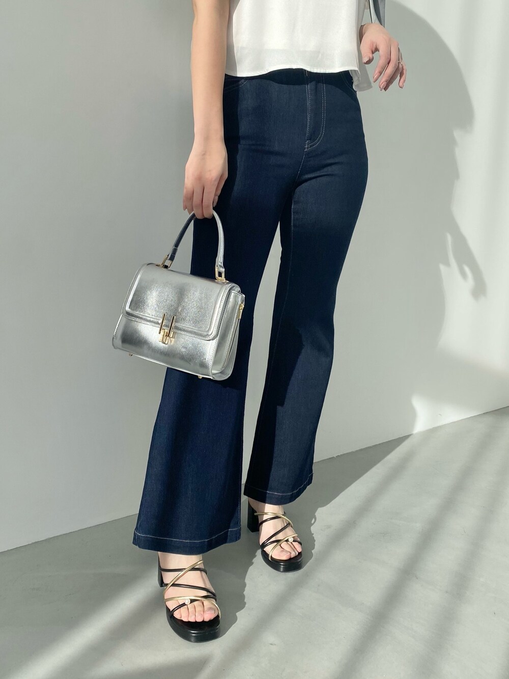 ホワイト系のシャツ/ブラウス、ブルー系のデニムパンツ、ブラック系のサンダルを着用したレディースの春コーディネートの6枚目の写真