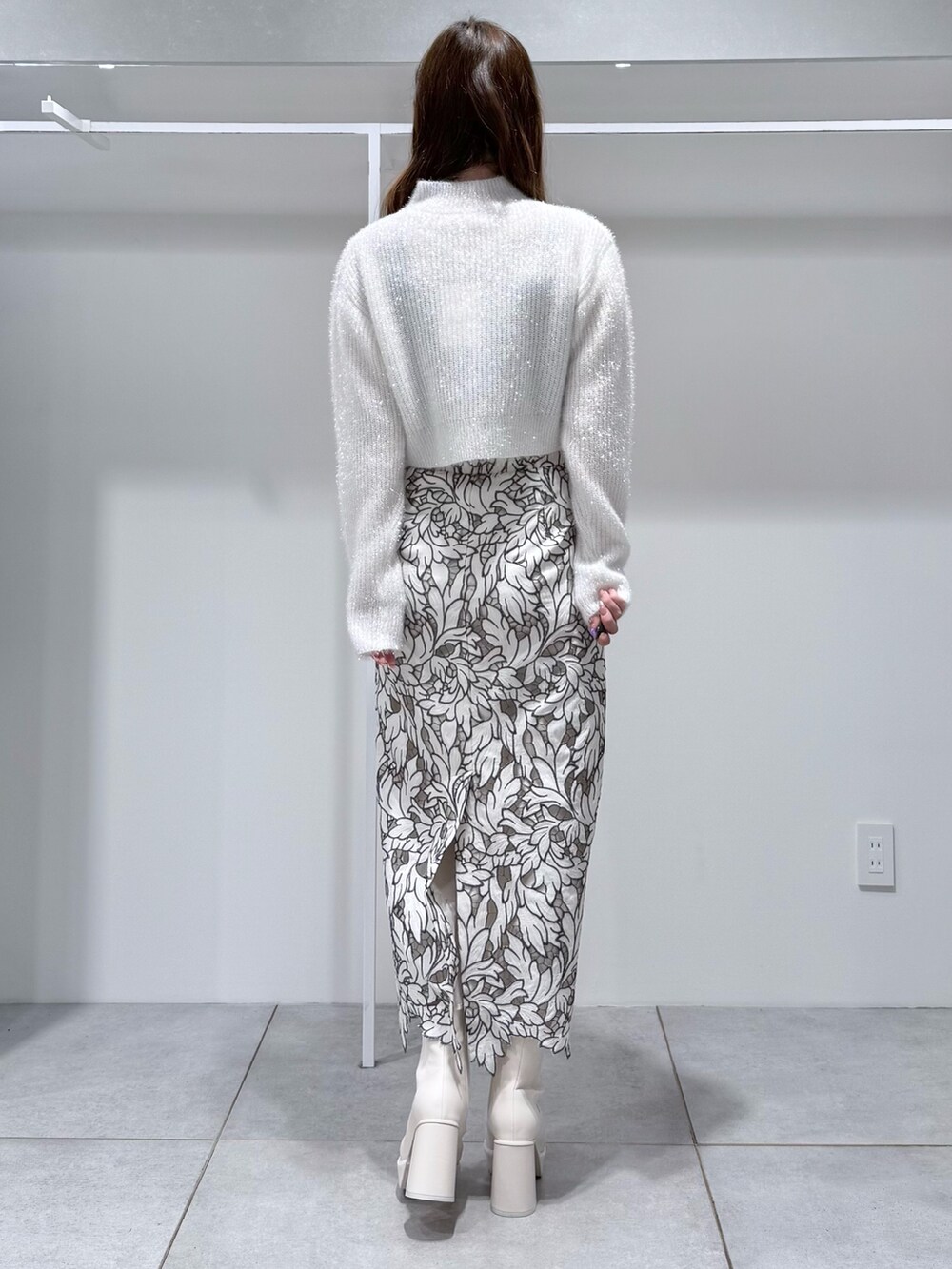 ホワイト系のニット/セーター、ホワイト系のスカート、ホワイト系のブーツを着用したレディースの冬コーディネートの4枚目の写真