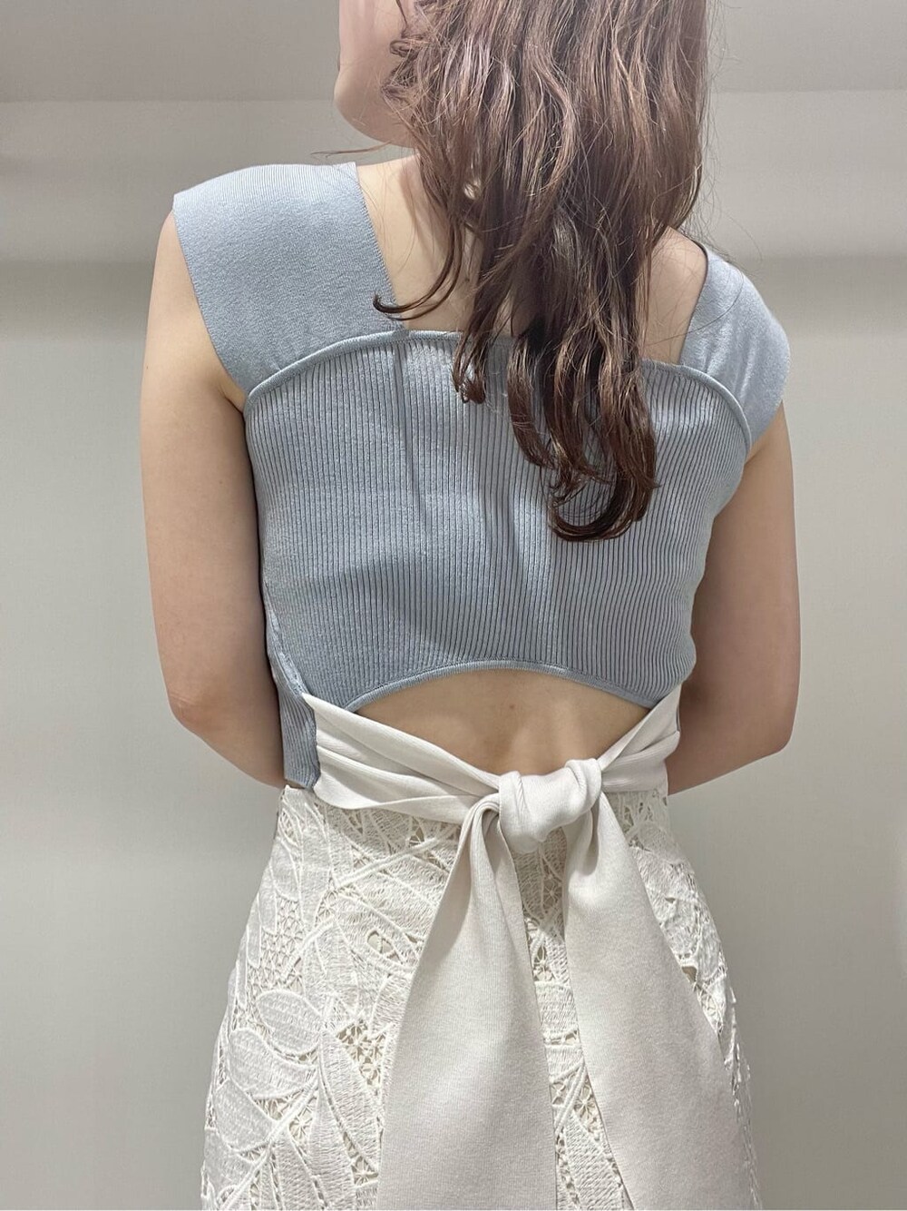 ホワイト系のスカート、ベージュ系のサンダル、ブルー系のニット/セーターを着用したレディースの夏コーディネートの5枚目の写真