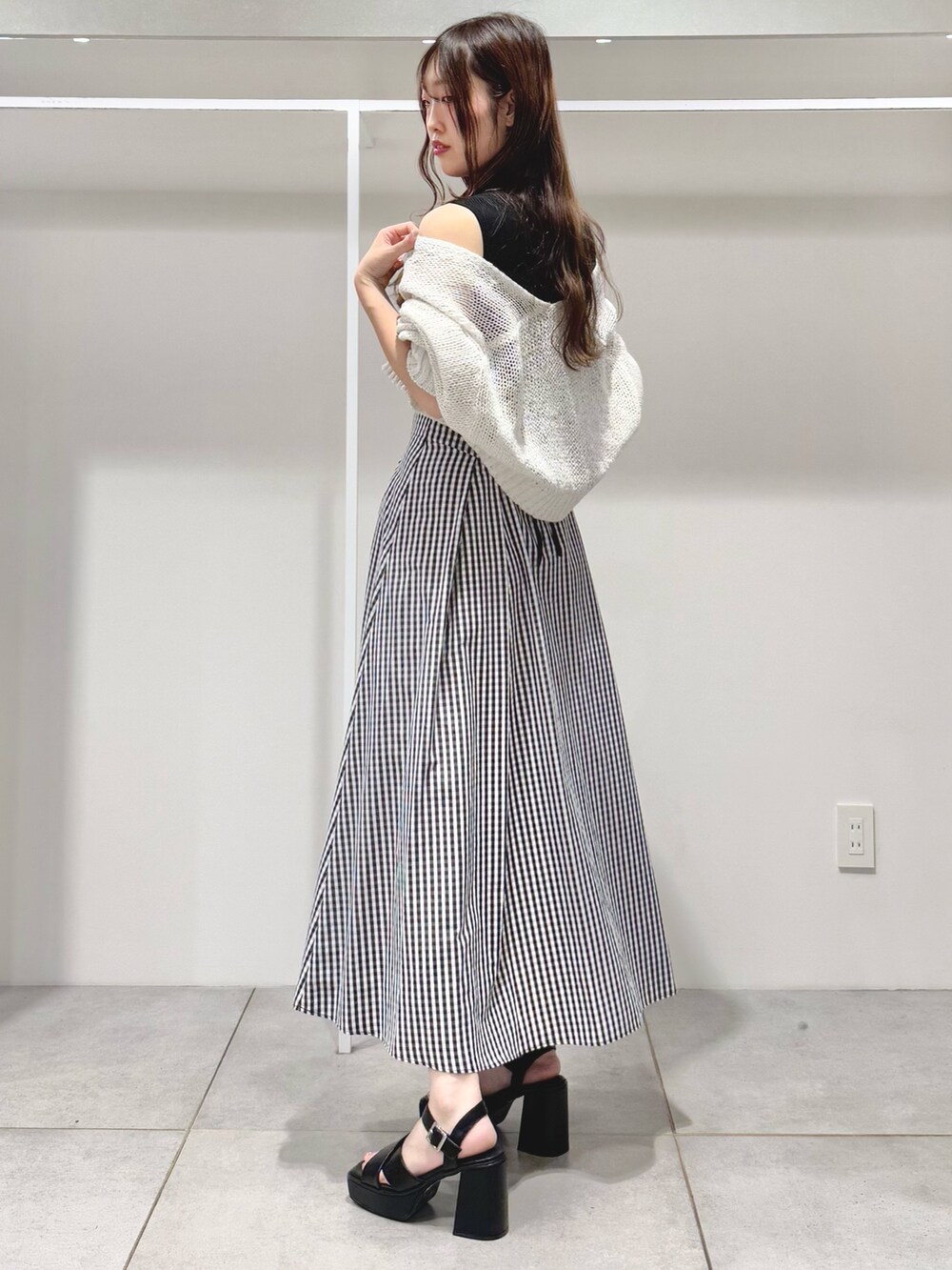 ブラック系のサンダル、その他のスカート、ブラック系のニット/セーターを着用したレディースの春コーディネートの4枚目の写真