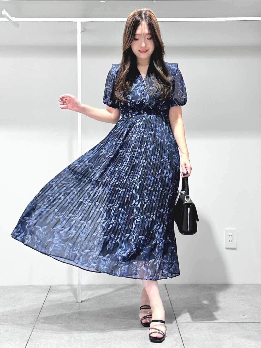 ブルー系のワンピース、ブラック系のショルダーバッグ、ブラック系のサンダルを着用したレディースの夏コーディネートの2枚目の写真