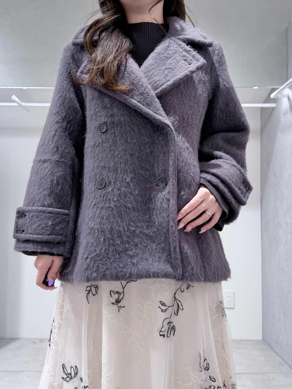 グレー系のその他アウター、グレー系のニット/セーター、ホワイト系のスカートを着用したレディースの冬コーディネートの5枚目の写真