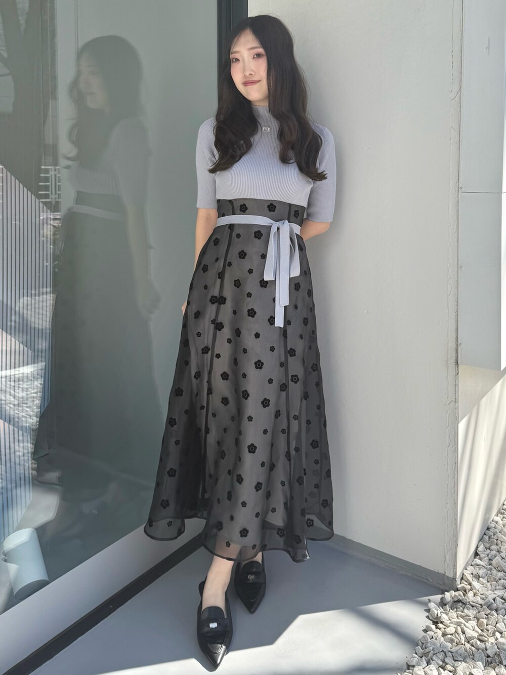 グレー系のワンピース、ブラック系のパンプスを着用したレディースの春コーディネートの2枚目の写真