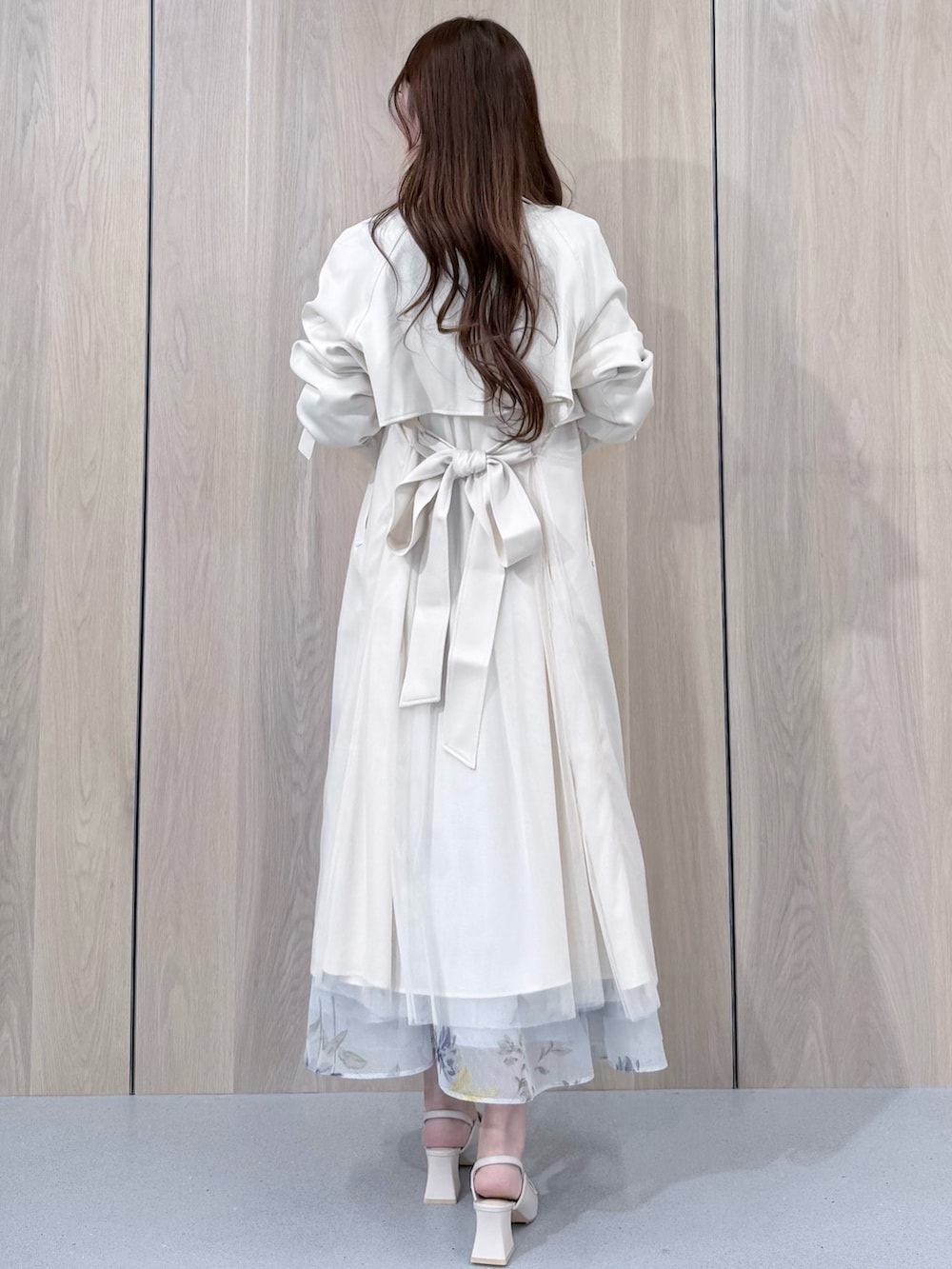 グリーン系のシャツ/ブラウス、グリーン系のスカート、ホワイト系のトレンチコートを着用したレディースの春コーディネートの3枚目の写真